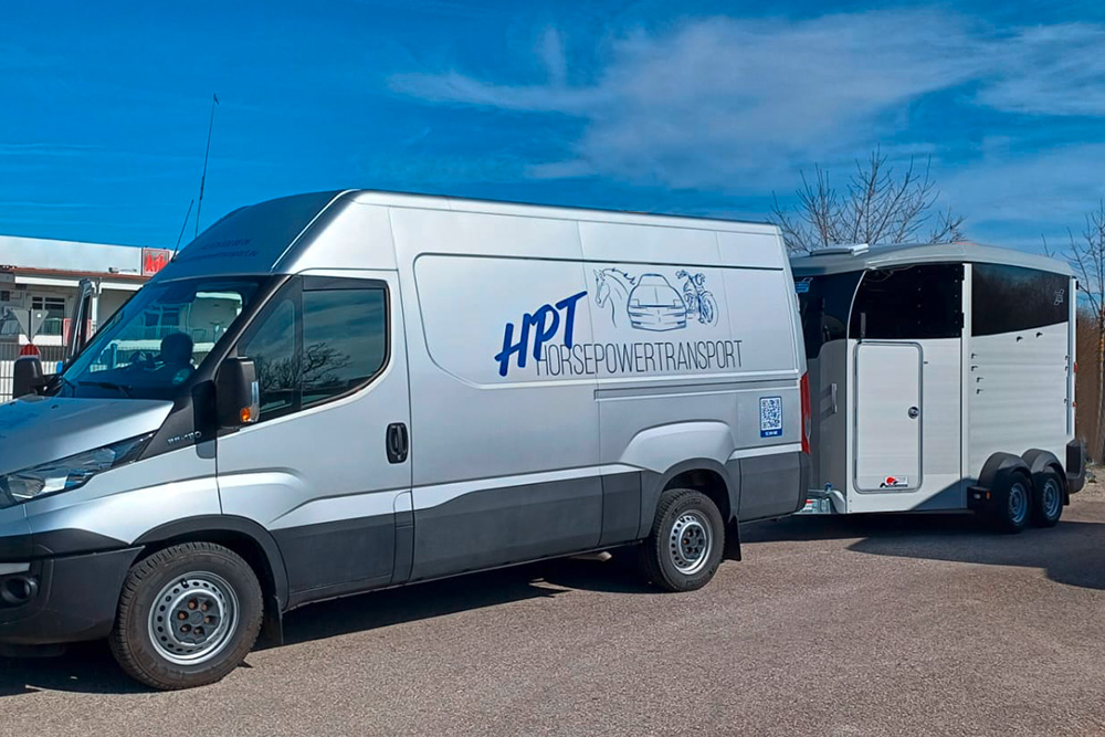 Grauer Transporter mit Pferdeanhänger für Pferdetransport